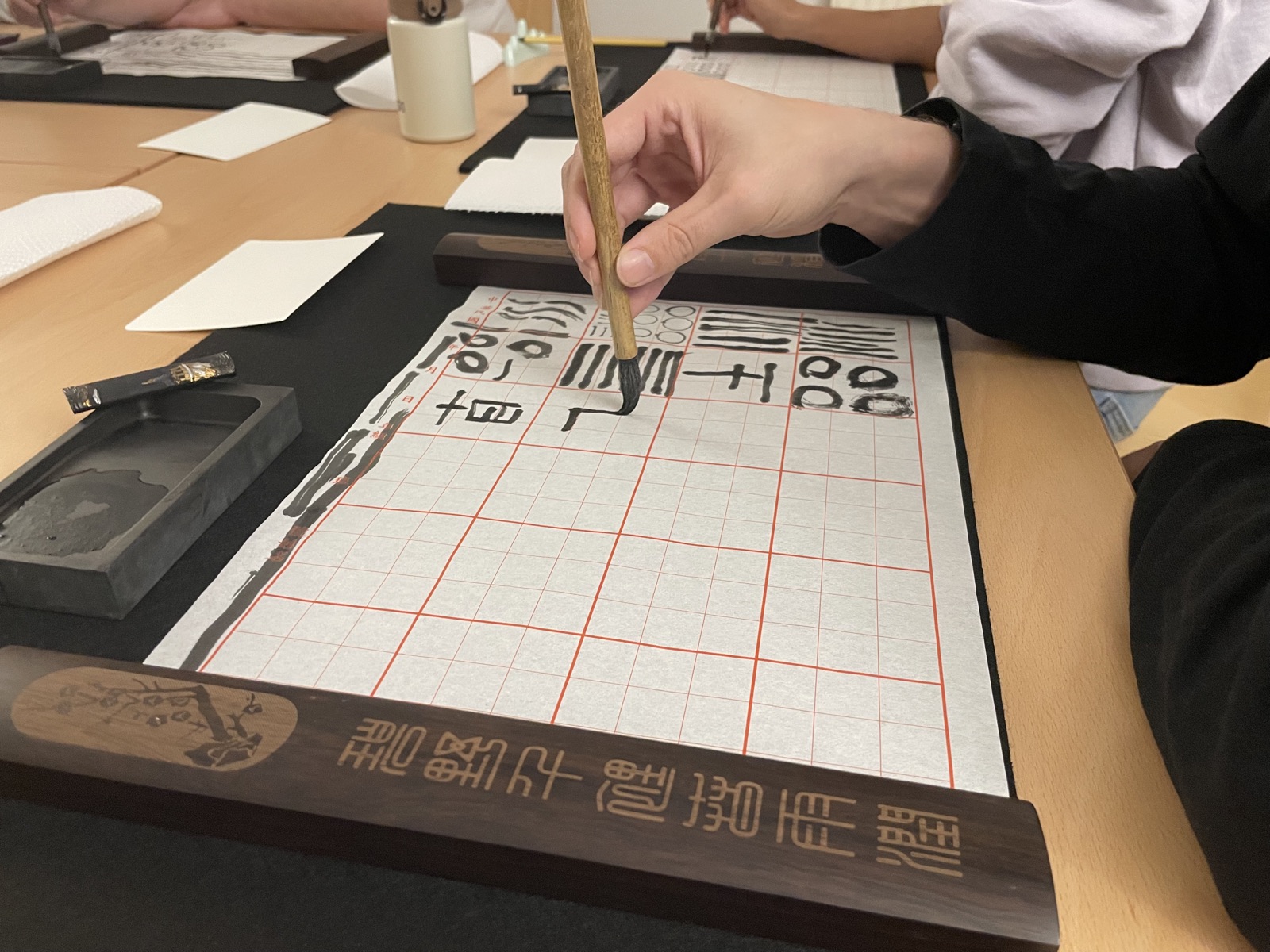 书法课上的篆书习字纸、毛笔与砚台